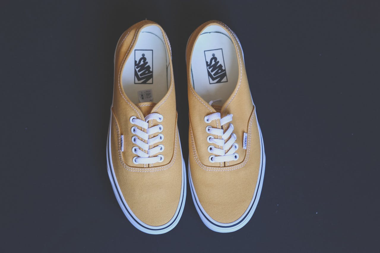home-hero Pair of stylish yellow sneakers on a black background showcasing fashion and footwear design.