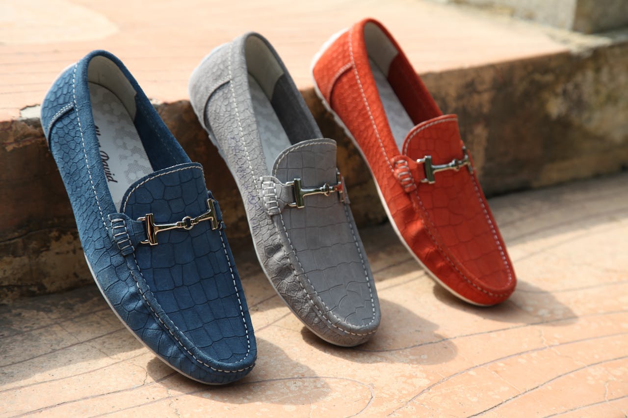 services-06 Three colorful leather loafers displayed outdoors showcasing style and elegance.